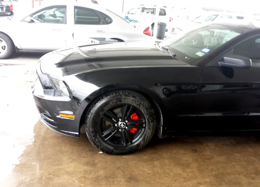 Black Ford Mustang with black wheels and red brake calipers